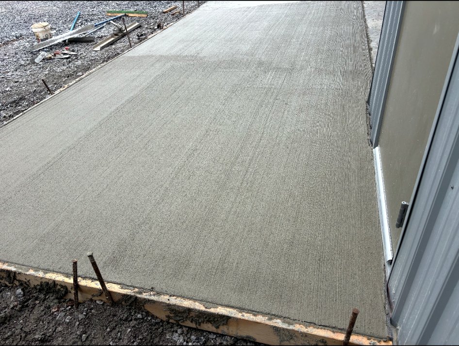 Freshly finished concrete approach beside a building.